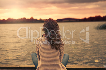 Frau sitzt am See