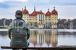 Person looks at the baroque castle Moritzburg