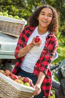 Mixed Race Female Teenager Leaning on Tractor Eating Apple
