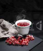 hot tea from red viburnum in a white ceramic cup