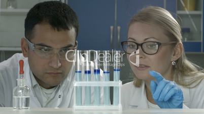 Scientists studying substance in test tubes in lab