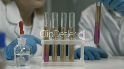 Researcher dropping the reagent into test tube