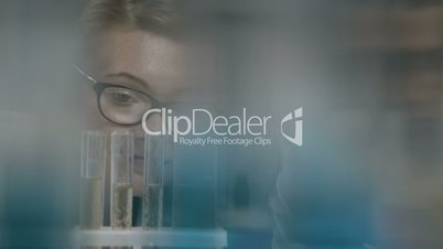 Female scientist examining test tube in lab