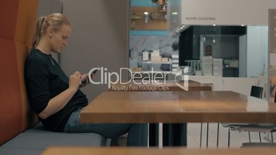 Woman in cafe browsing web on mobile