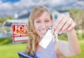 Woman Holding New House Keys with Blank Card In Front of Sold Re