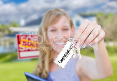 Woman Holding New House Keys with Congratulations Card In Front