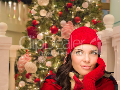 Warmly Dressed Female In Front of Decorated Christmas Tree.