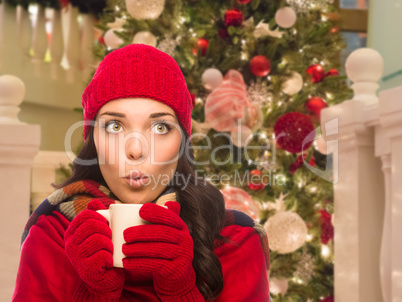 Warmly Dressed Female With Mug In Front of Decorated Christmas T