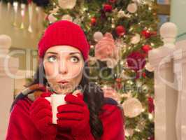 Warmly Dressed Female With Mug In Front of Decorated Christmas T