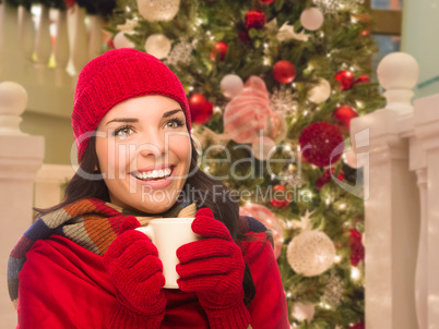 Warmly Dressed Female With Mug In Front of Decorated Christmas T