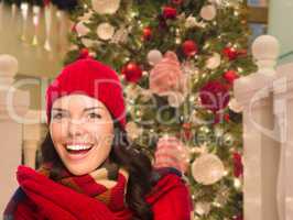 Warmly Dressed Female In Front of Decorated Christmas Tree.