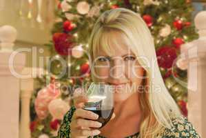 Blond Woman with Wine Glass In Front of Decrated Christmas Tree.