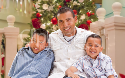 Hispanic Young Father and Sons In Front of Decorated Christmas T