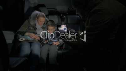 Taking mobile video of mom and kid traveling by minibus and using cell