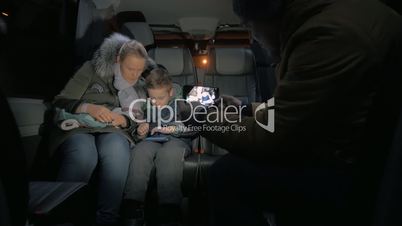 Minibus travel. Taking mobile video of mom and kid playing on cellphone