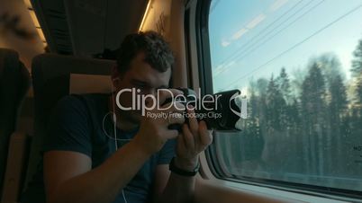 Man stocker in train listening to music and making footage