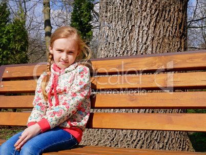 Small girl sits on the bench