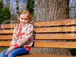 Small girl sits on the bench