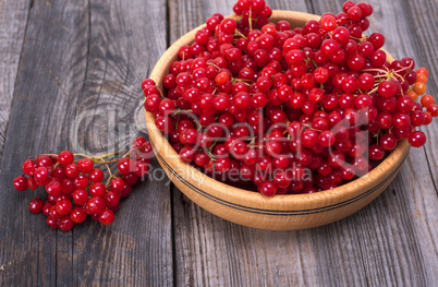 bunch of red viburnum in a wooden bowl