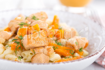 Braised chicken meat with carrot in sauce and pasta