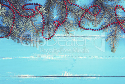 green spruce branches with a red Christmas garland