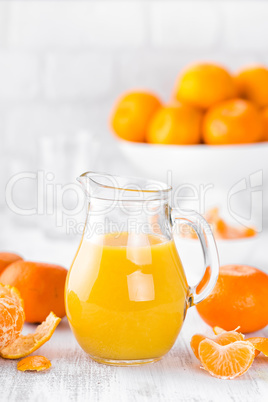 Tangerines, peeled tangerines and tangerine juice in glass. Mandarine juice.