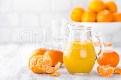Tangerines, peeled tangerines and tangerine juice in glass. Mandarine juice.