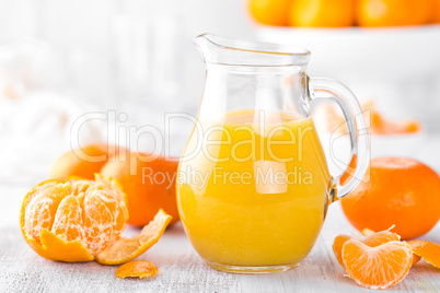 Tangerines, peeled tangerines and tangerine juice in glass. Mandarine juice.