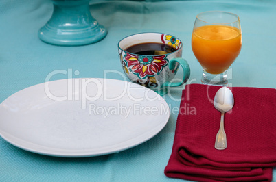 Black coffee in a colorful flower print cup with orange juice