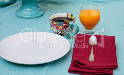 Black coffee in a colorful flower print cup with orange juice