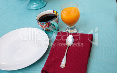 Black coffee in a colorful flower print cup with orange juice