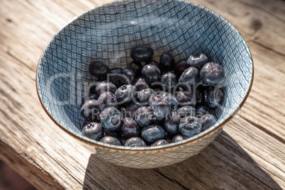 Organic blueberries in a blue and white bowl