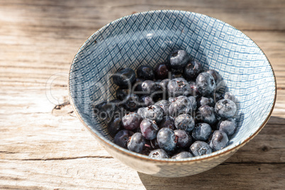 Organic blueberries in a blue and white bowl