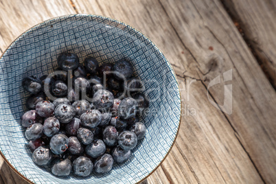 Organic blueberries in a blue and white bowl