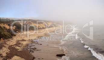 Fog drifts in over the ocean at Crystal Cove state beach