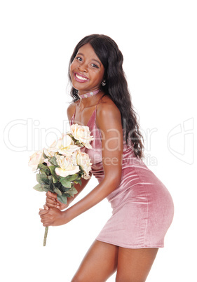 A happy woman in a pink dress with yellow roses
