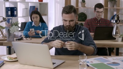 Office worker taking painkillers at workplace