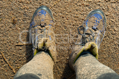 Close up of man's boots while hiking on trail in the mountains.