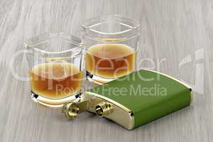 Green hip flask and glasses of whisky