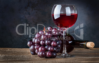 Glass wine with grapes and bottle