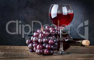 Glass wine with grapes and bottle