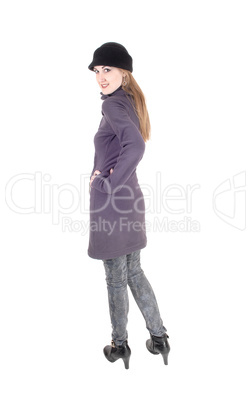 Woman standing in winter coat looking over shoulder