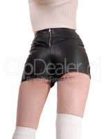 Woman standing in leather shorts from back
