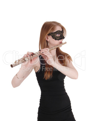Woman standing and playing the flute with a mask