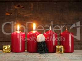 Four red candles on a wooden background
