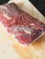 Raw goose breast on a wooden board