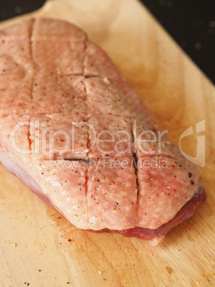 Raw goose breast on a wooden board