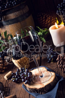 Red wine from a barrel with grapes and a glass of wine