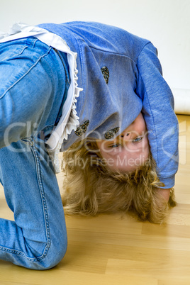 young blond girl is kidding on the floor