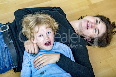 young blond girl is kidding with aunt on the floor